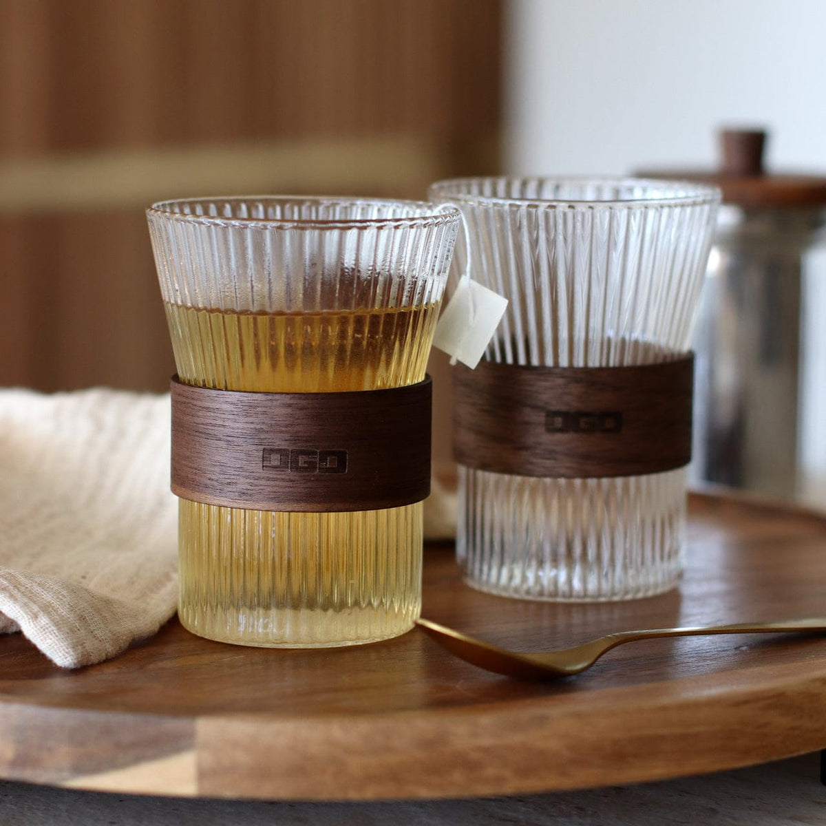 Twee glazen kopjes met thee op een houten dienblad