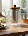 Glazen theepot met thee naast een ontbijt op een houten tafel